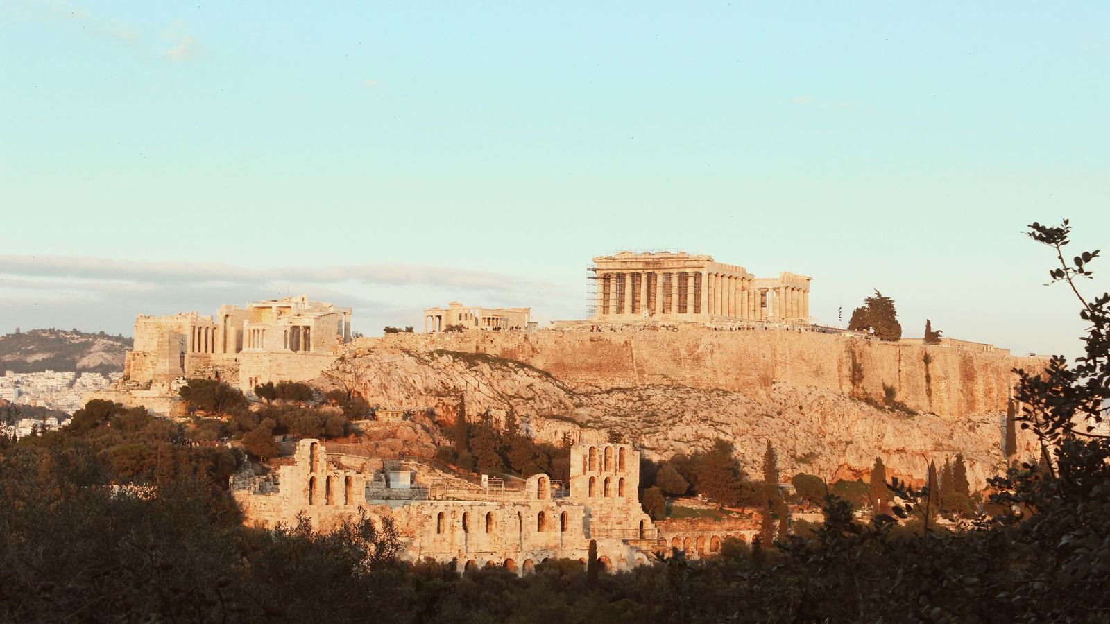 The Acropolis of Athens and the Parthenon in golden evening light above the Odeon of Herodes Atticus